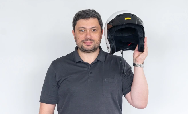 Employee Christian Neudorfer holds helmet next to his head