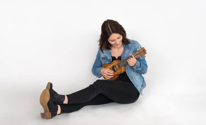 Mitarbeiterin Christina Lehner spielt Ukulele.