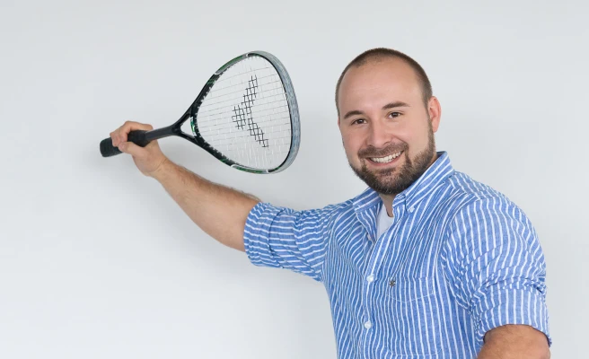 Mitarbeiter Florian Hager mit Squashschläger