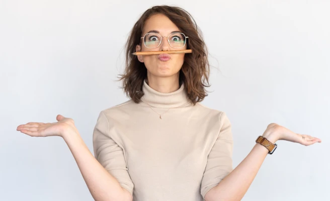 Employee Kathrin Hager has clamped a pencil between her upper lip and nose.