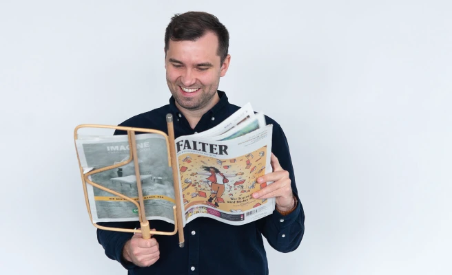Mitarbeiter Martin Heindl liest Wochenzeitung 