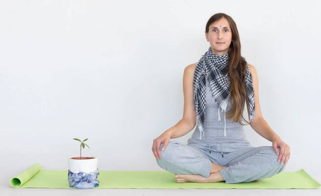 Employee Melanie Trchlin sits on a yoga mat.