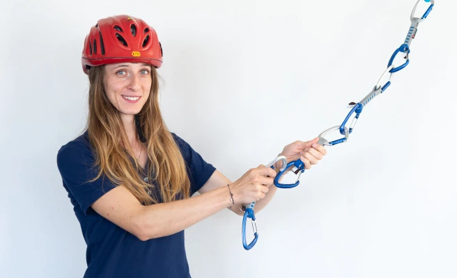 Mitarbeiterin Sara Fregnan trägt Kletterhelm und hakt Karabiner ein.