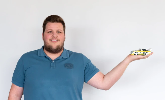 Mitarbeiter Simon Peham zeigt Modellauto.
