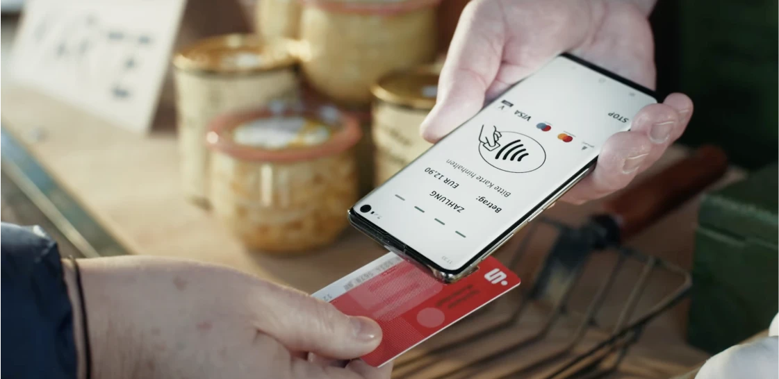 Kontaktloses Bezahlen mit Bankkarte an Smartphone mit Sparkasse-POS App.