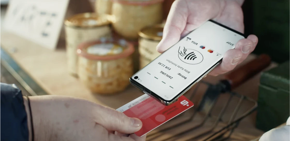 Contactless payment with bank card on smartphone with Sparkasse POS app.