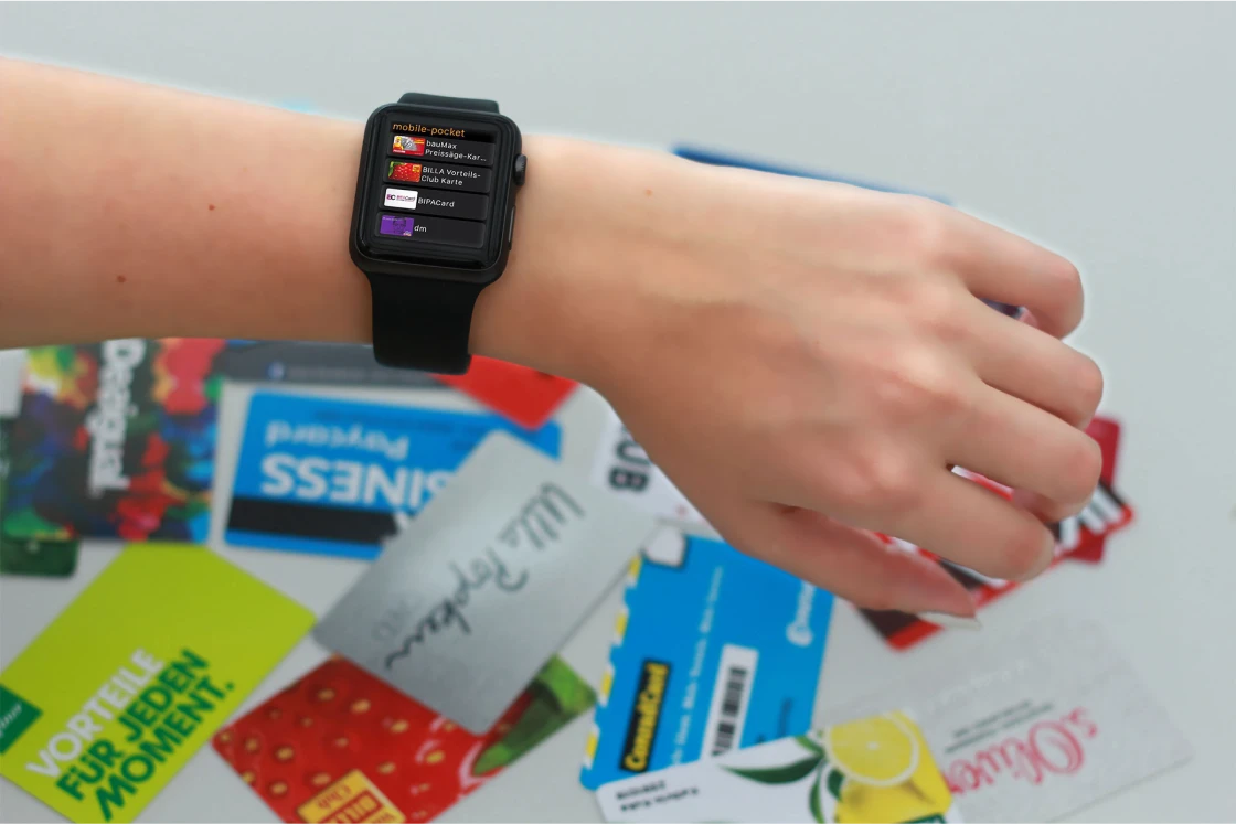 Handgelenk mit Smartwatch, die mobile-pocket zeigt, vor lauter physischen Kundenkarten.