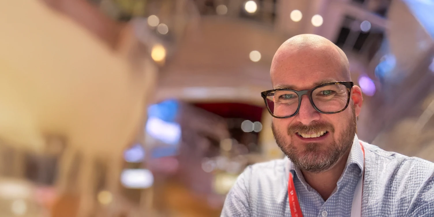 Profilaufnahme von Peter Rubik, er trägt Brille, Bart und ein weiß-blau kariertes Hemd.