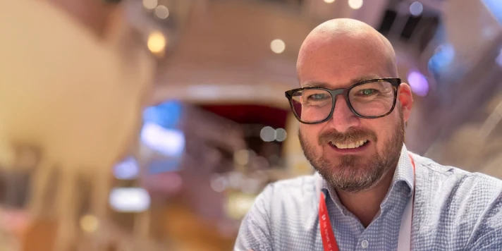 Profilaufnahme von Peter Rubik, er trägt Brille, Bart und ein weiß-blau kariertes Hemd.