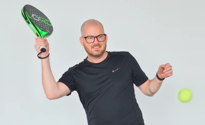 MItarbeiter Peter Rubik mit Tennisschläger und Tennisball